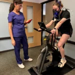 Clinician using PNOE metabolic testing device during cardiopulmonary assessment session