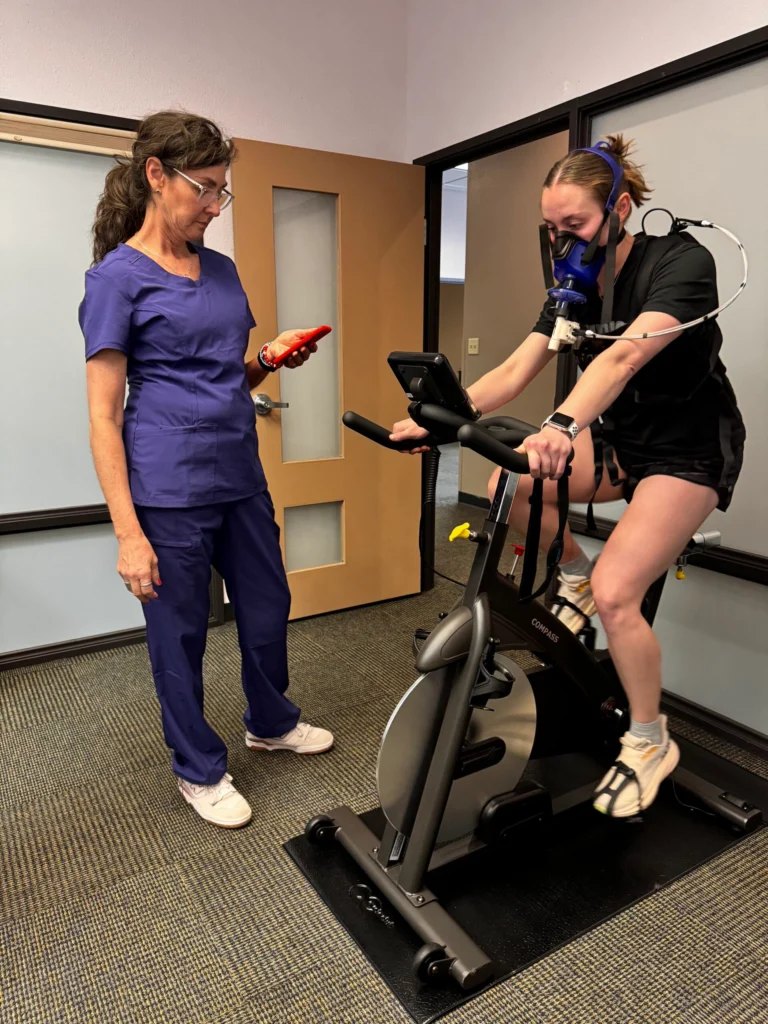 Clinician using PNOE metabolic testing device during cardiopulmonary assessment session